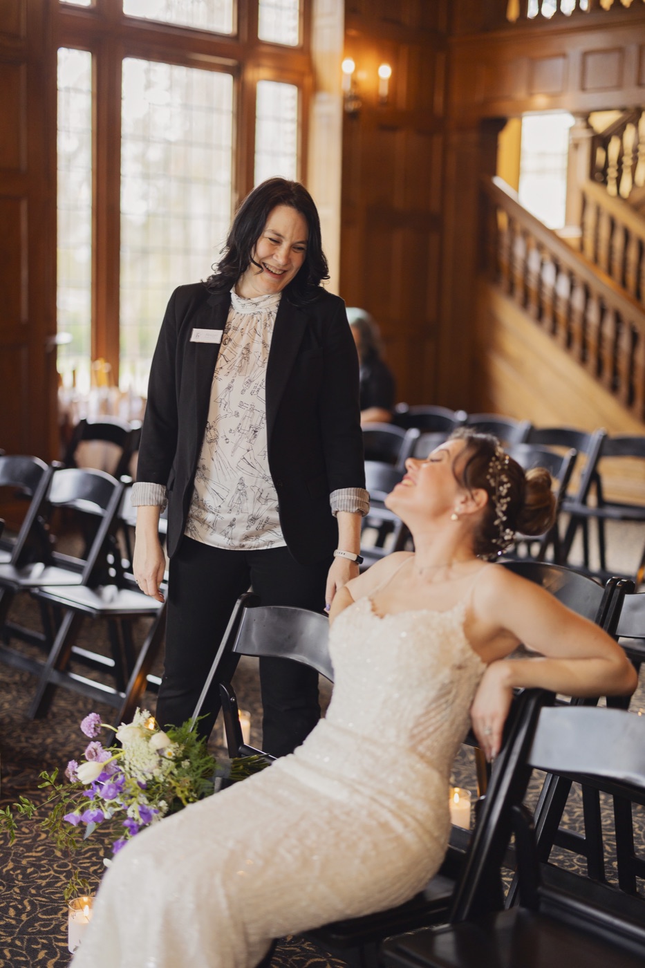 Abagail laughing with a bride during a quiet moment at the wedding