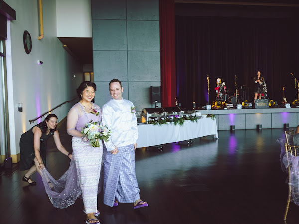 Abagail holding the bride's dress train, ducking out of the photo
